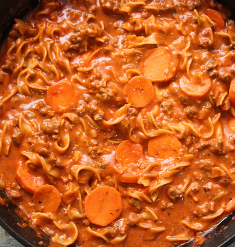 One-pan winter warmer beef and noodles simmering in a cast iron skillet