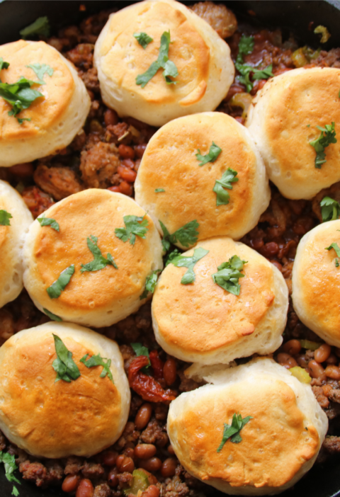 Cure-All One-Pan Comfort Skillet with beef, sausage, maple beans, and golden biscuits in a cast-iron pan