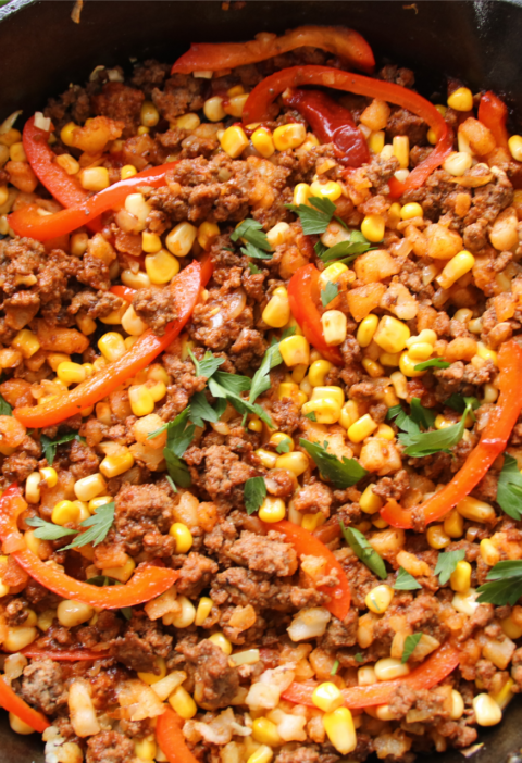 Smoky BBQ ground beef hash cooked in a skillet with potatoes and corn
