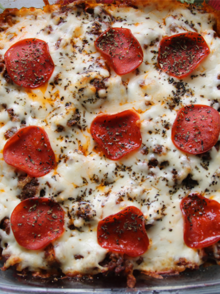 Meat lover's ground beef pizza casserole with penne pasta, pepperoni, and melted mozzarella cheese