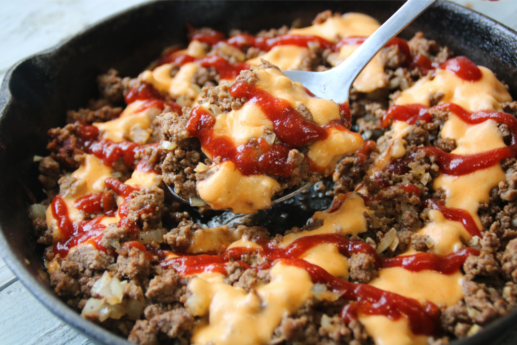 Saucy Ground Beef Skillet topped with creamy cheddar sauce and tangy sauce
