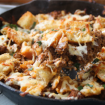 Meaty garlic bread bake with ground beef and melted cheese in a cast iron skillet