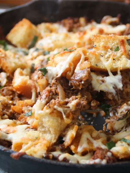 Meaty garlic bread bake with ground beef and melted cheese in a cast iron skillet