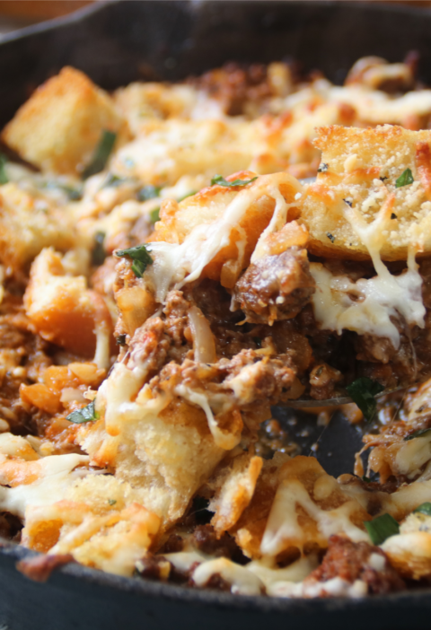 Meaty garlic bread bake with ground beef and melted cheese in a cast iron skillet