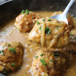 Old fashioned chicken and gravy supper with crispy chicken thighs in rich onion gravy served in a rustic skillet.