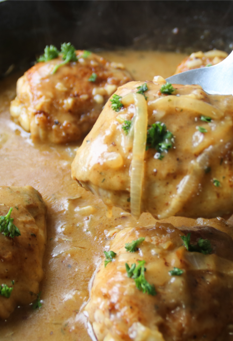 Old fashioned chicken and gravy supper with crispy chicken thighs in rich onion gravy served in a rustic skillet.