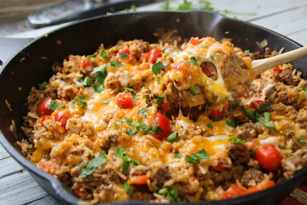 One pan ground beef supper with rice, tomatoes, and bell peppers cooked in a skillet