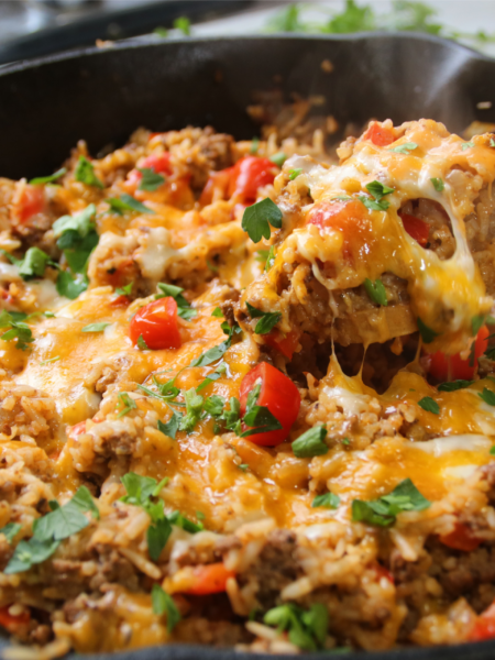 One pan ground beef supper with rice, tomatoes, and bell peppers cooked in a skillet