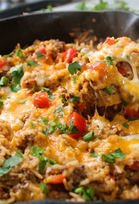 One pan ground beef supper with rice, tomatoes, and bell peppers cooked in a skillet