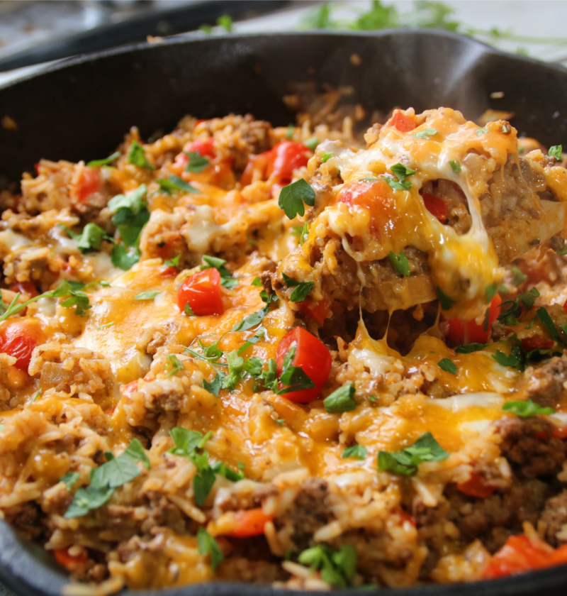 One pan ground beef supper with rice, tomatoes, and bell peppers cooked in a skillet