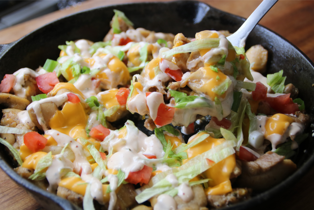 KFC Chicken Burger Skillet served with melted American cheese, burger sauce, lettuce, tomatoes, and toasted sesame buns