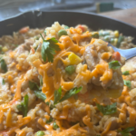 Ole Uncle Joe's Chicken & Rice Supper served in a skillet with tender chicken, fluffy rice, mixed vegetables, and melted cheddar cheese.