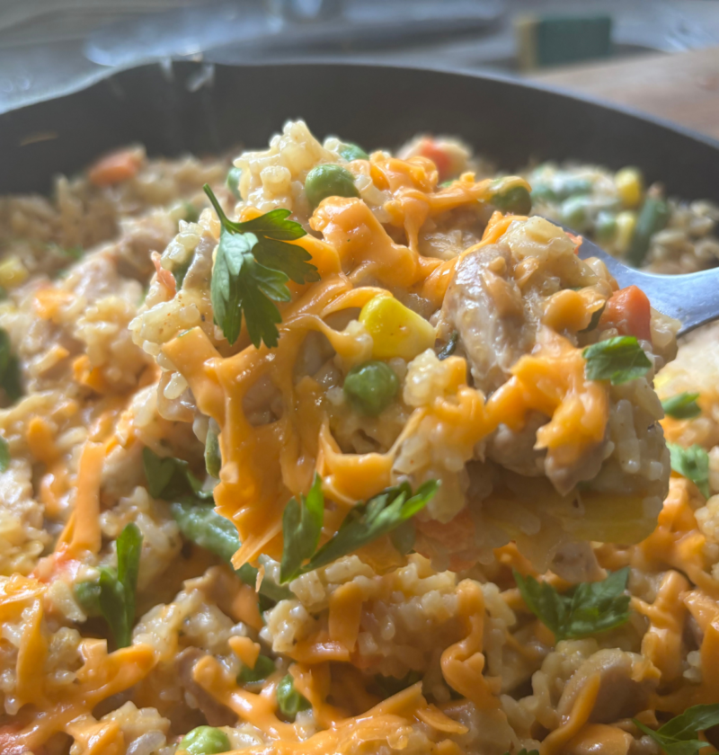 Ole Uncle Joe's Chicken & Rice Supper served in a skillet with tender chicken, fluffy rice, mixed vegetables, and melted cheddar cheese.