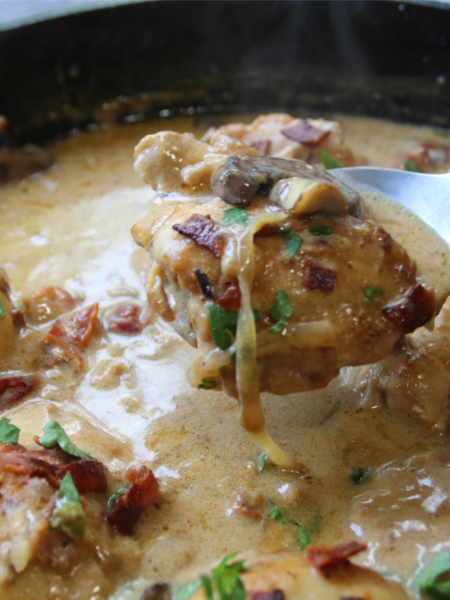 Old Time Creamy Chicken Skillet with tender chicken, crispy bacon, mushrooms, onions, and creamy Parmesan gravy in a cast-iron skillet.