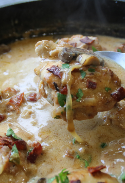 Old Time Creamy Chicken Skillet with tender chicken, crispy bacon, mushrooms, onions, and creamy Parmesan gravy in a cast-iron skillet.