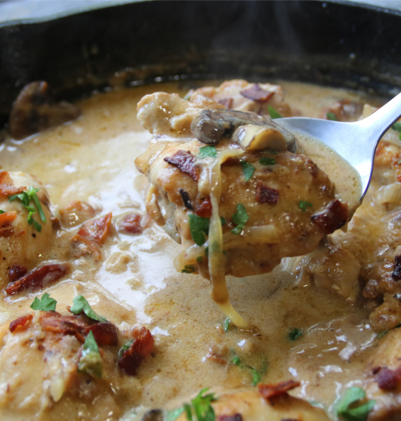 Old Time Creamy Chicken Skillet with tender chicken, crispy bacon, mushrooms, onions, and creamy Parmesan gravy in a cast-iron skillet.