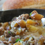 Old Time Ground Beef Magic with potatoes, sliced onions, and rich beef gravy in a cast iron skillet